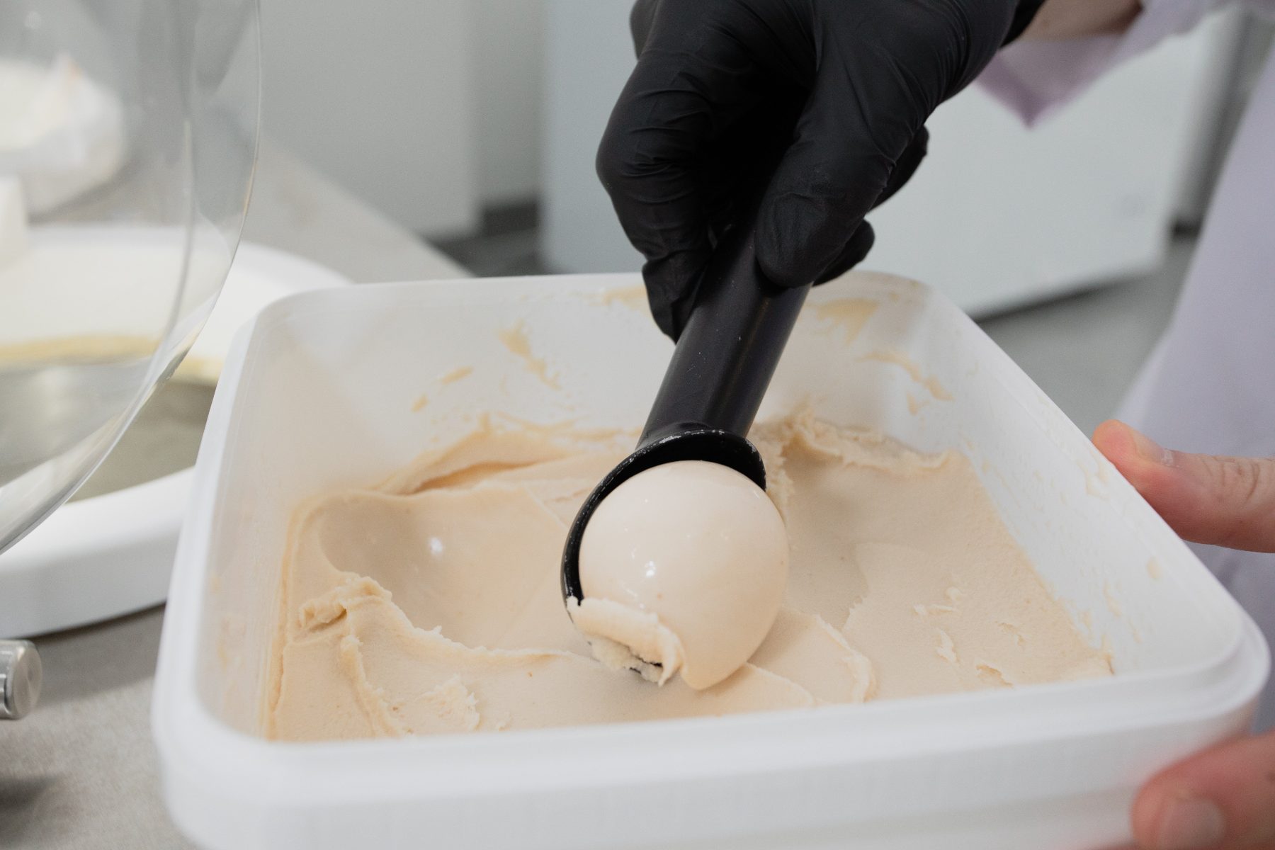 Scooping fresh gelato from the tub