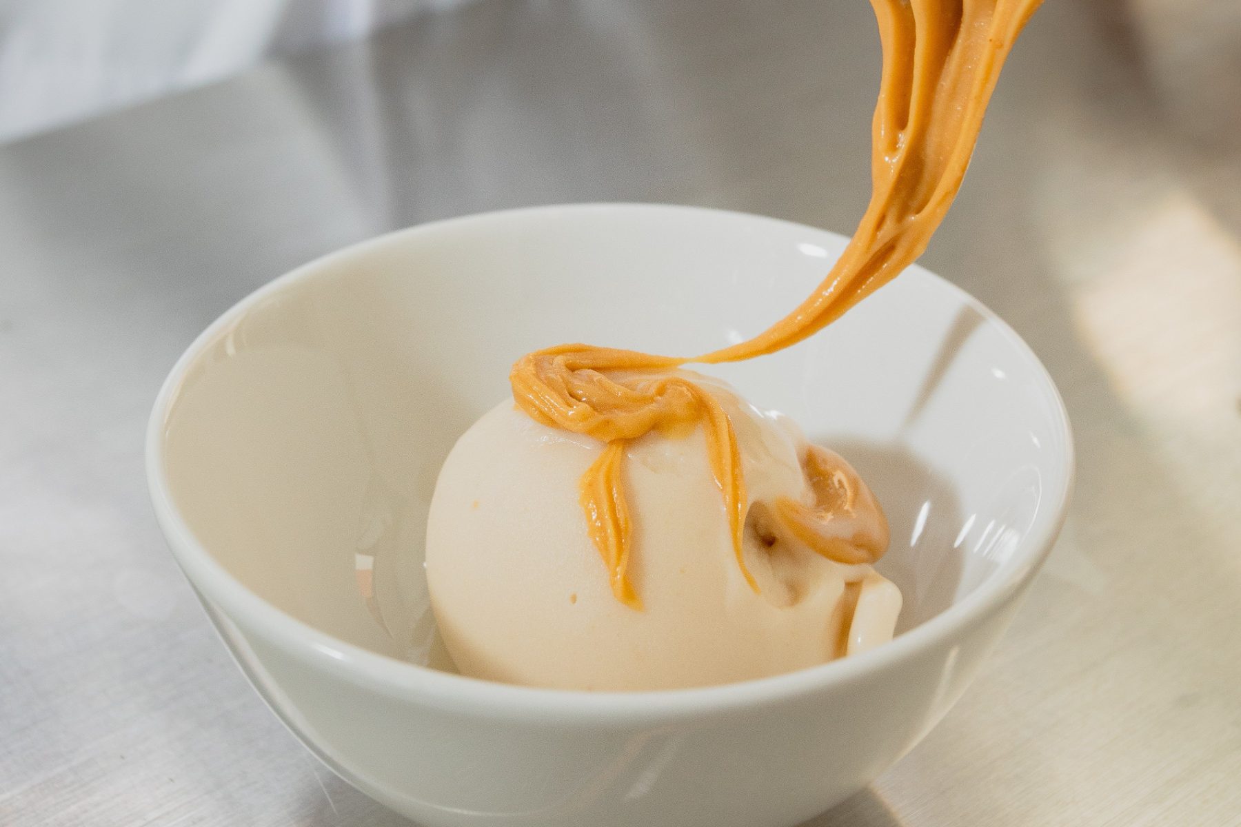 A scoop finished with a thread of caramel